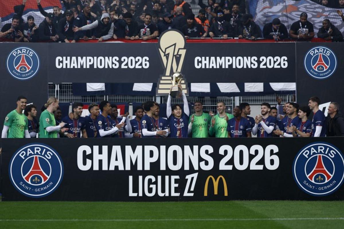 Paris Saint-Germain's South Korean midfielder #19 Lee Kang-in (C) lifts the French Ligue 1 trophy as he celebrates alongside teammates after winning the championship ahead of the French L1 football match between Paris FC and Paris Saint-Germain (PSG) at the Stade Jean-Bouin in Paris on May 17, 2026. Kenzo TRIBOUILLARD / AFP