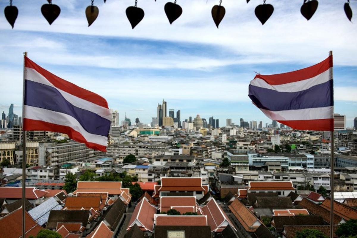 This photo taken on June 26, 2023 shows Thai flags fluttering in the wind in the backdrop of Bangkok skyline seen from the Wat Saket Buddhist temple. Amaury PAUL / AFP