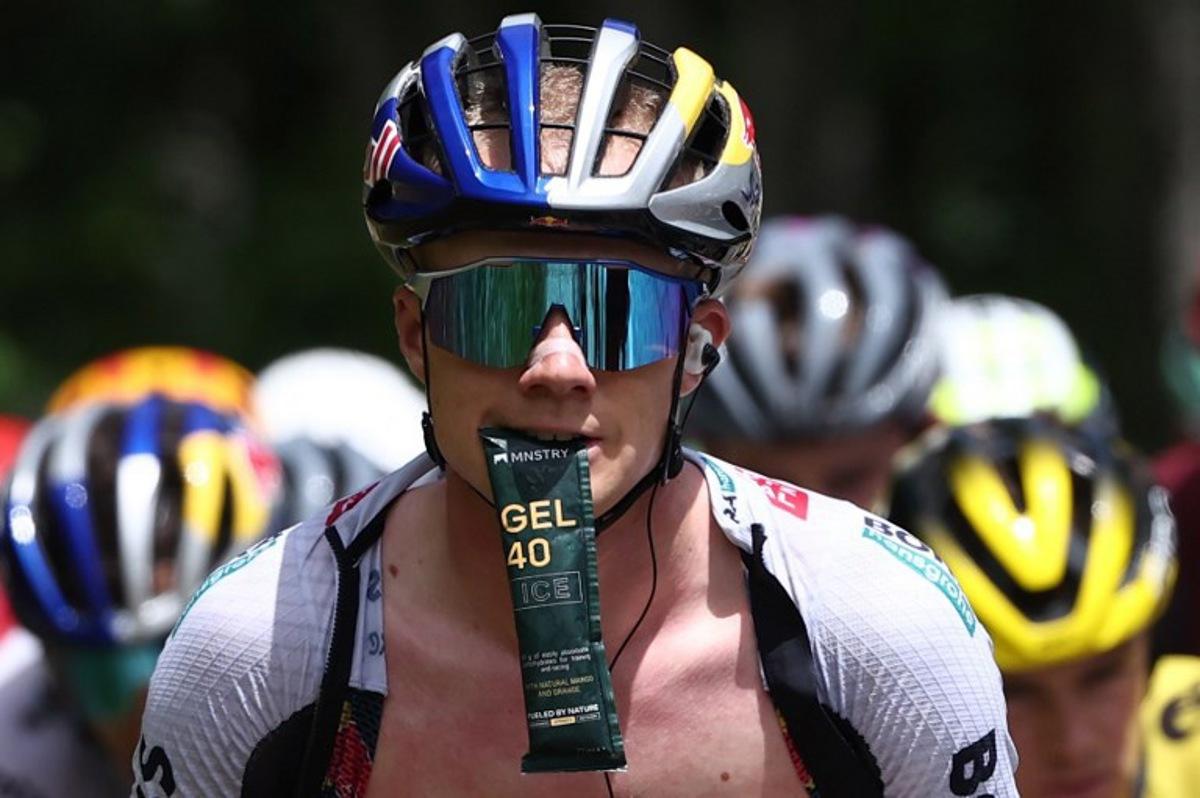Red Bull - BORA - hansgrohe's Belgian rider Maxim Van Gils holds an energy gel in his mouth during the 7th stage of the 77th edition of the Criterium du Dauphine cycling race, 131,6 km between Grand-Aigueblanche and Valmeinier, on June 14, 2025. Anne-Christine POUJOULAT / AFP