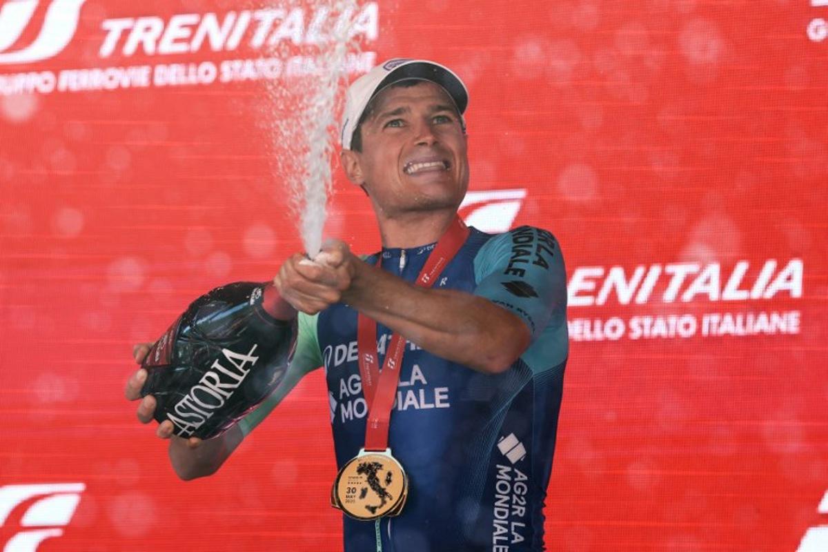 Decathlon AG2R La Mondiale Team's French rider Nicolas Prodhomme sprays champagne as hecelebrates on the podium after victory in the 19th stage of the 108th Giro d'Italia cycling race of 166kms from Biella to Champoluc on May 30, 2025. Luca Bettini / AFP