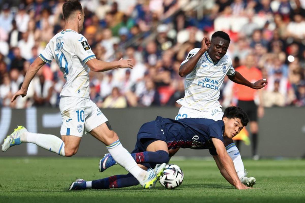 Paris Saint-Germain's Spanish midfielder #27 Dro Fernandez (C) fights for the ball with Lorient's French midfielder #10 Pablo Pagis (L) and Cameroonian midfielder #62 Arthur Avom (R) during the French L1 football match between Paris Saint-Germain (PSG) and FC Lorient at Parc des Princes stadium in Paris on May 2, 2026. FRANCK FIFE / AFP