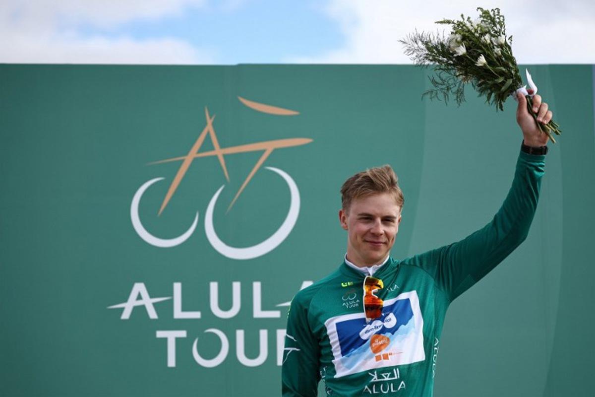 Dutch Casper van Uden (DSM-Firmenich PostNL), first at the general classification, holds flowers on the podium after the third stage between Al-Ula International Airport and Al-Ula Camel Cup Track, during the Al-Ula Tour cycling race at Al-Ula Camel Cup Track on February 1, 2024. Anne-Christine POUJOULAT / AFP