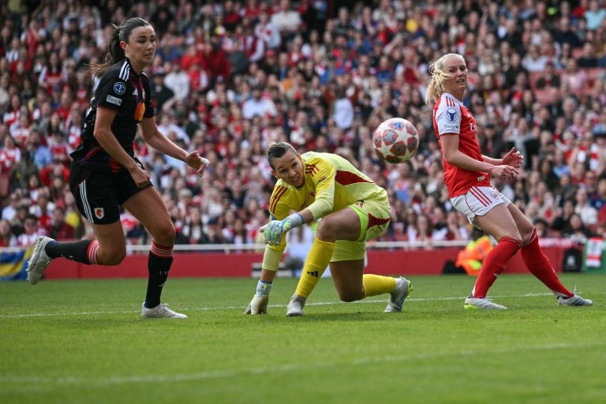 Arsenal's Swedish striker #25 Stina Blackstenius (R) and Lyon's Chilean goalkeeper #01 Christiane Endler (C) watch a bobbled ball to in for a goal during the women's UEFA Champions League first-leg semi-final football match between Arsenal and OL Lyonnes at the Emirates Stadium, north London, on April 26, 2026. Glyn KIRK / AFP