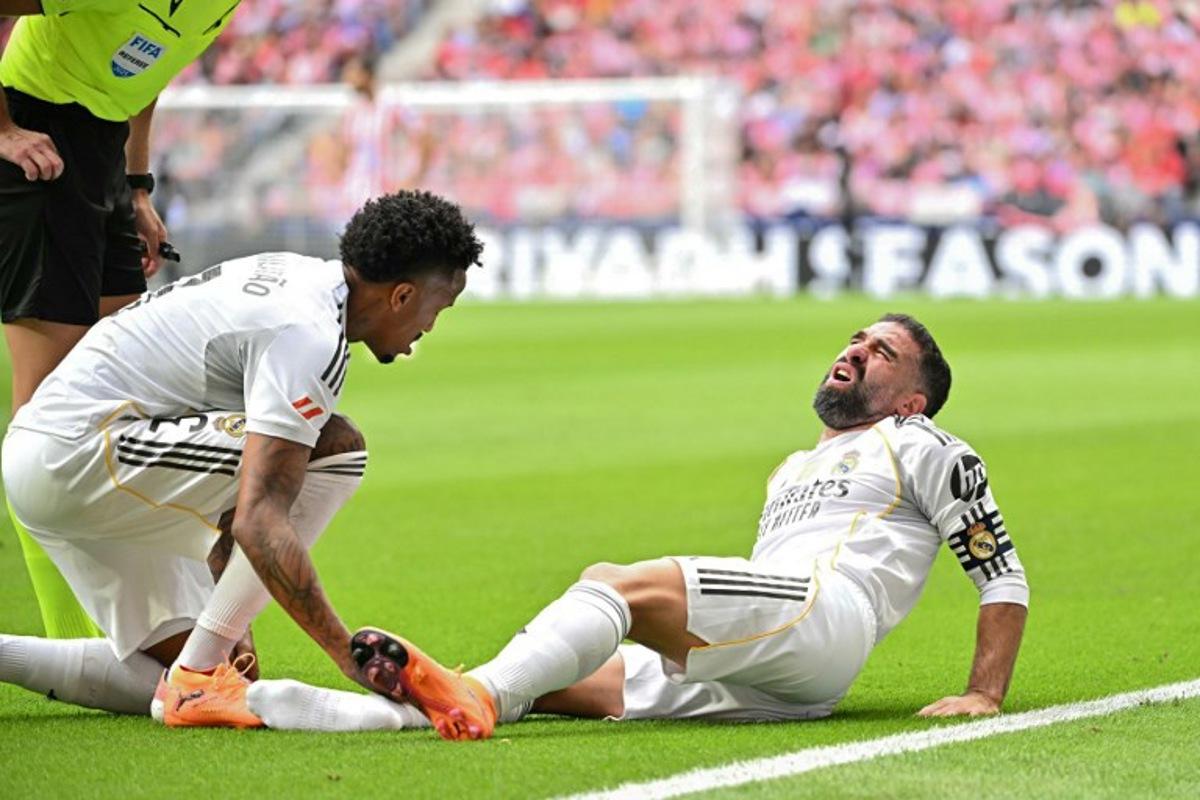 Real Madrid's Spanish defender #02 Dani Carvajal reacts on the ground during the Spanish league football match between Club Atletico de Madrid and Real Madrid CF at the Metropolitano stadium in Madrid on September 27, 2025. Javier SORIANO / AFP