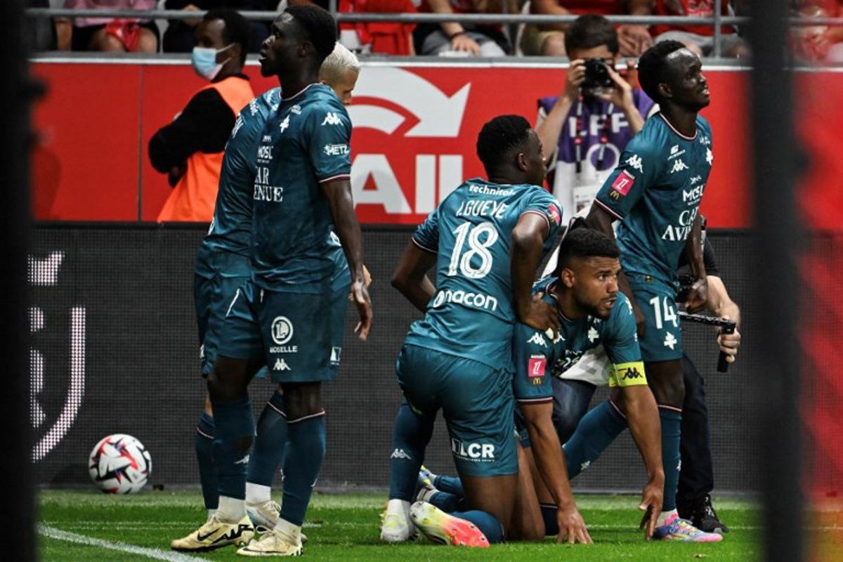 Metz' players celebrate after Metz's French defender #03 Matthieu Udol (2R) scored a goal during the French L1-L2 playoff second leg football match between Stade de Reims and FC Metz at Stade Auguste-Delaune in Reims, northern France on May 29, 2025. FRANCOIS NASCIMBENI / AFP