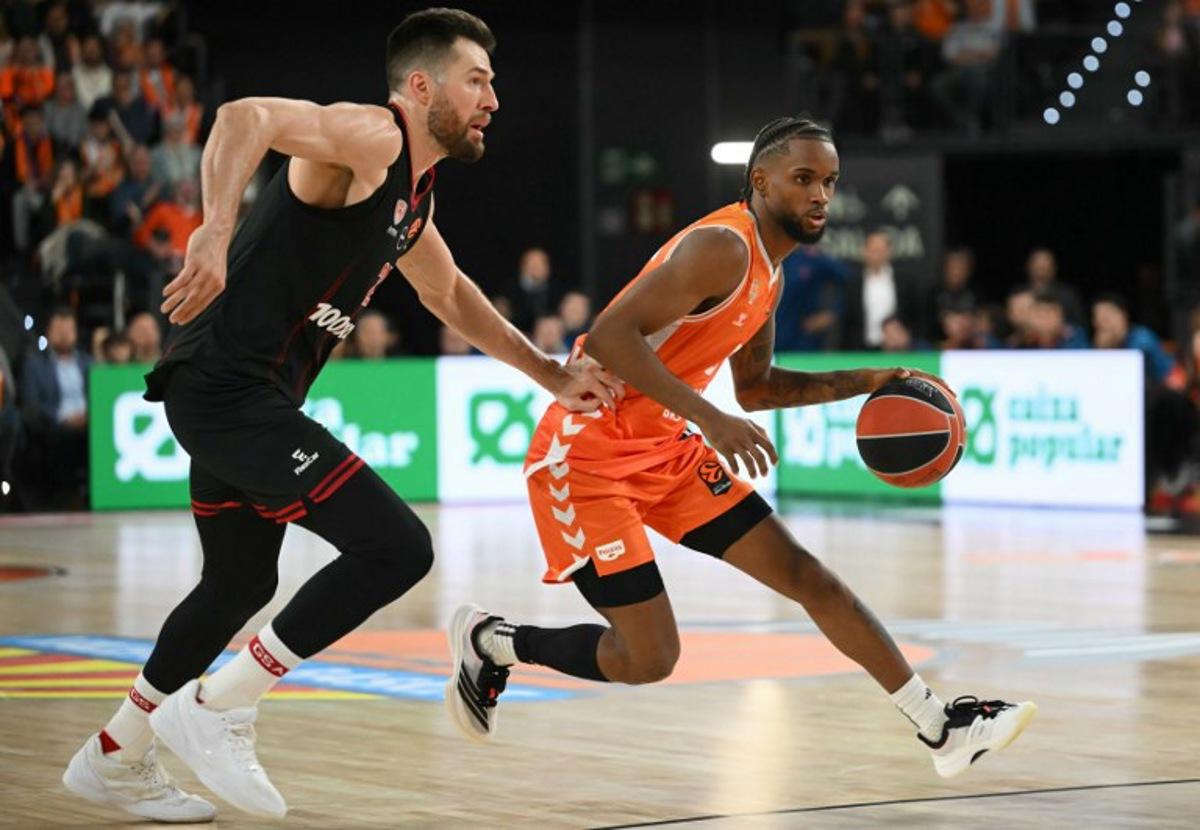 Valencia's Dominican Republic guard #8 Juan Montero drives the ball against Olympiacos Piraeus' US forward #25 Alec Peters during the Euroleague basketball match between Valencia Basket and Olympiacos at the Roig arena in Valencia on March 24, 2026. JOSE JORDAN / AFP