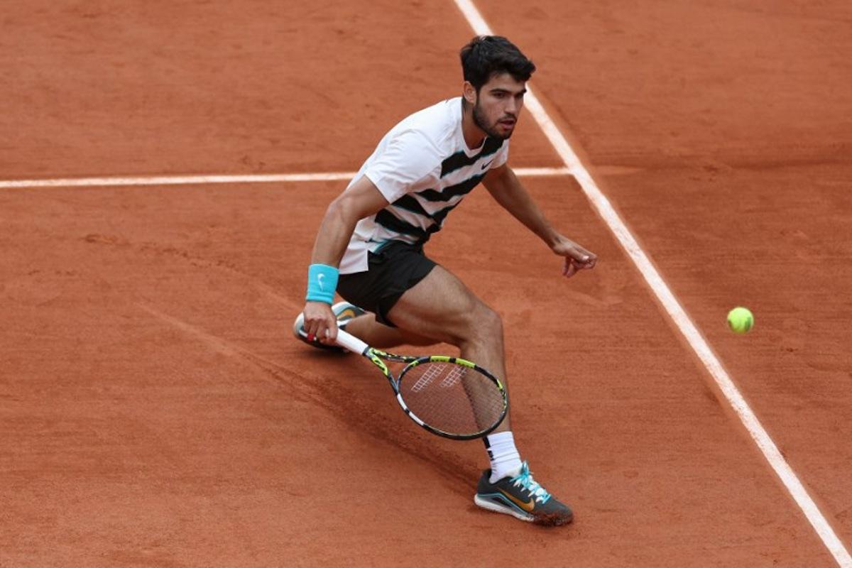 Spain's Carlos Alcaraz plays a backhand return to Italy's Giulio Zeppieri during their men's singles match on day 2 of the French Open tennis tournament on Court Suzanne-Lenglen at the Roland-Garros Complex in Paris on May 26, 2025. Franck FIFE / AFP