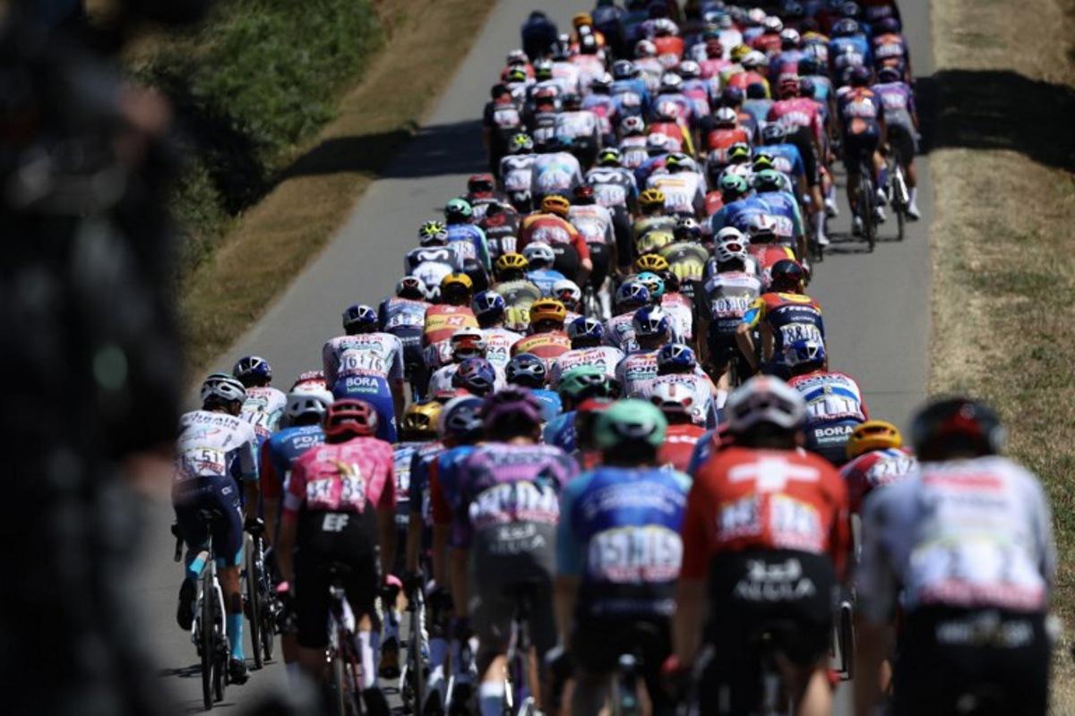 The pack of riders (peloton) cycles during the 8th stage of the 112th edition of the Tour de France cycling race, 171.4 km between Saint-Meen-le-Grand and Laval Espace Mayenne, western France, on July 12, 2025. Anne-Christine POUJOULAT / AFP