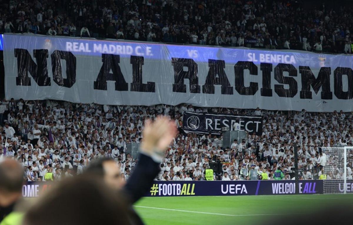 A banner against racism is pictured before the UEFA Champions League knockout round play-off second leg football match between Real Madrid CF and SL Benfica at Santiago Bernabeu Stadium in Madrid on February 25, 2026. Thomas COEX / AFP