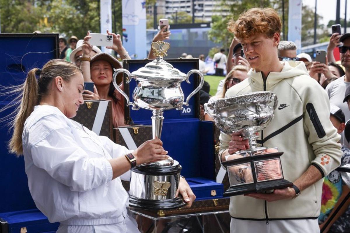 Current Australian Open tennis champions Aryna Sabalenka (L) of Belarus and Italy's Jannik Sinner hold the trophies as part of an offical ceremony for the main draw, ahead of the Australian Open tennis tournament in Melbourne on January 9, 2025. DAVID GRAY / AFP