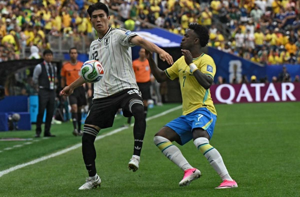 Japan's defender #22 Takehiro Tomiyasu (L) fights for the ball with Brazil's forward #07 Vinicius Junior during the 2026 World Cup round of 32 football match between Brazil and Japan at the Houston Stadium in Houston on June 29, 2026. RONALDO SCHEMIDT / AFP