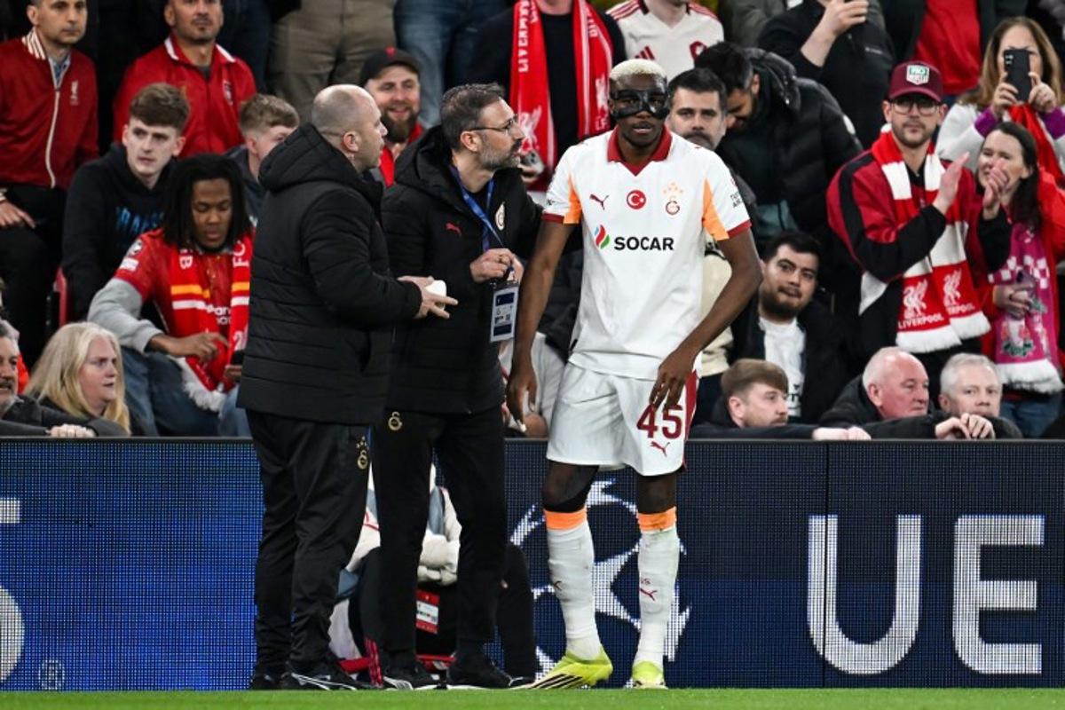 Galatasaray's Nigerian forward #45 Victor Osimhen (R) receives medical treatment during the UEFA Champions League, round of 16 second leg football match between Liverpool and Galatasaray at Anfield in Liverpool, north-west England on March 18, 2026. Paul ELLIS / AFP