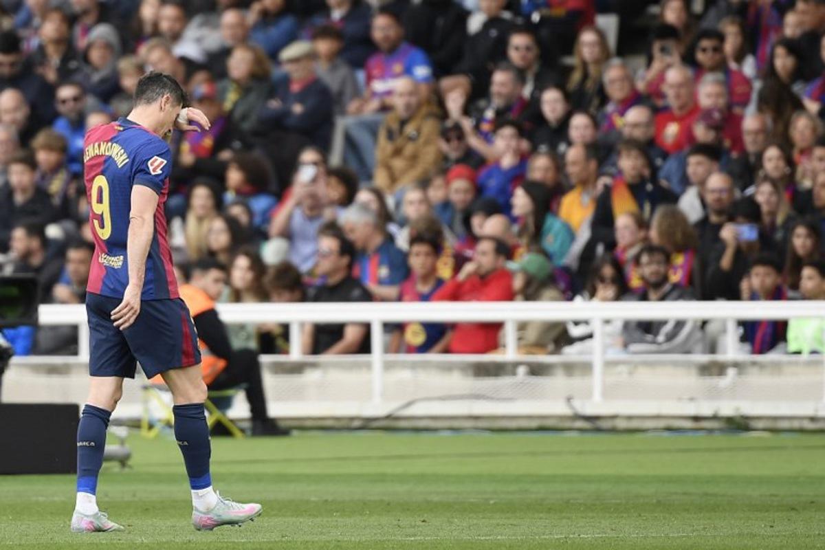 Barcelona's Polish forward #09 Robert Lewandowski leaves the pitch after resulting injured during the Spanish league football match between FC Barcelona and RC Celta de Vigo at the Estadi Olimpic Lluis Companys in Barcelona on April 19, 2025. Josep LAGO / AFP
