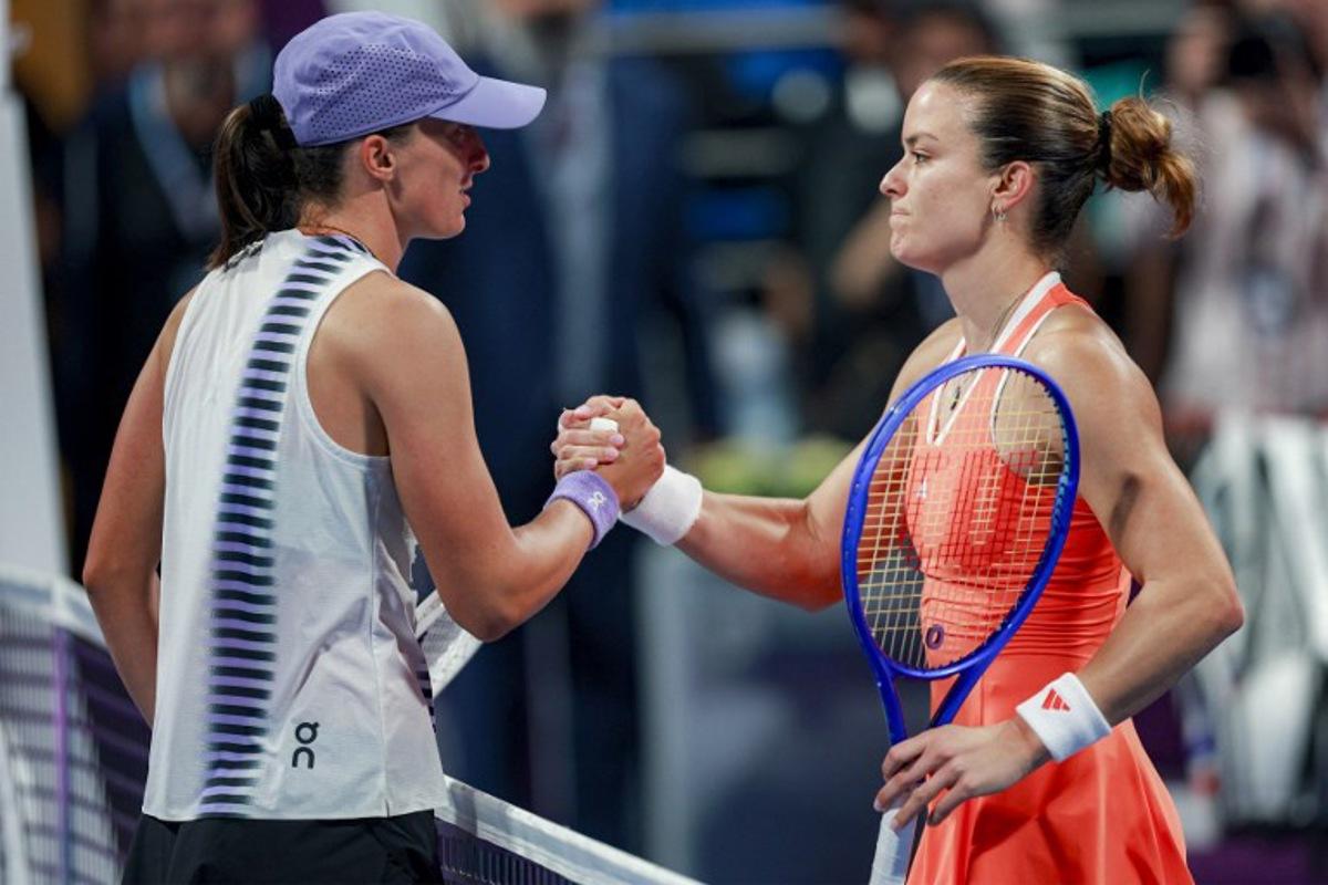 Greece's Maria Sakkari (R) is congratulated by Poland's Iga Swiatek after winning their women's singles quarter-final match at the Qatar Open tennis tournament in Doha on February 12, 2026. Karim JAAFAR / AFP