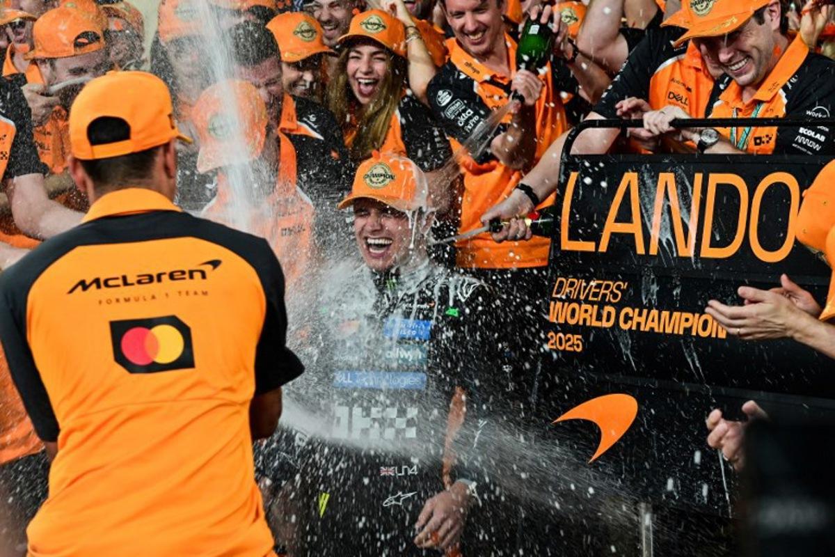 World champion and race third-placed McLaren's British driver Lando Norris (C) celebrates with his team at the end of the Abu Dhabi Formula One Grand Prix at the Yas Marina Circuit in Abu Dhabi on December 7, 2025. GIUSEPPE CACACE / AFP