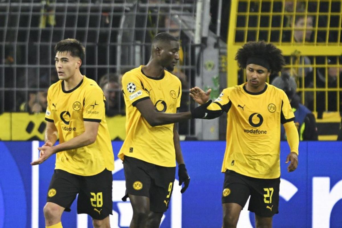 Dortmund's Guinean forward #09 Serhou Guirassy (C) celebrates with Dortmund's German forward #27 Karim Adeyemi (R) and Dortmund's Argentinian defender #28 Aaron Anselmino after scoring the opening 1-0 goal during the UEFA Champions League league phase day 5 football match between Borussia Dortmund and Villareal CF in Dortmund, on November 25, 2025. INA FASSBENDER / AFP
