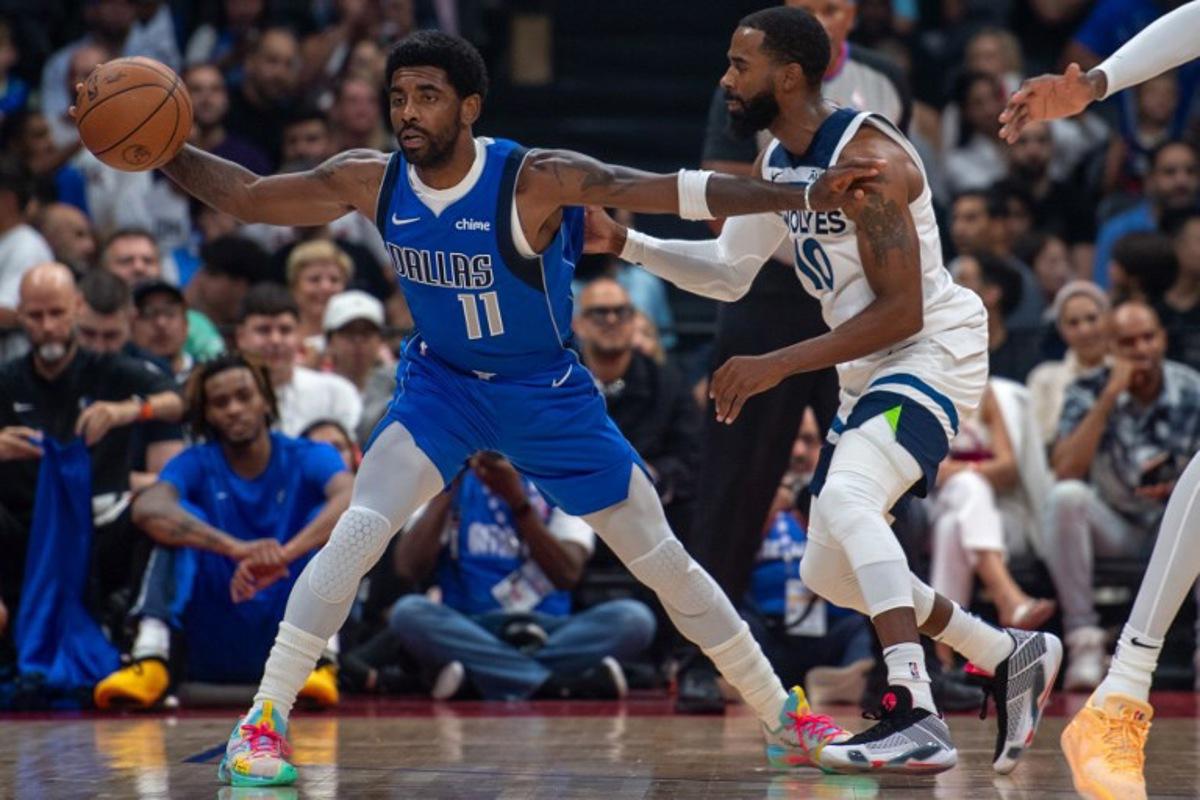 Dallas Mavericks' guard Kyrie Irving #11 is guarded by Minnesota Timberwolves' guard Mike Conley #10 during the NBA Preseason game Between the Dallas Mavericks and the Minnesota Timberwolves at the Etihad Arena in Abu Dhabi on October 5, 2023. Ryan LIM / AFP