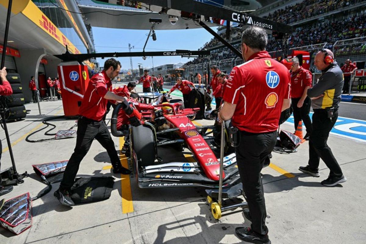 Mechanics work on the car of Ferrari's British driver Lewis Hamilton in the pits during the first practice session of the Formula One Chinese Grand Prix at the Shanghai International Circuit in Shanghai on March 21, 2025. HECTOR RETAMAL / AFP