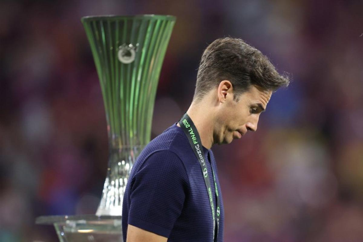 Rayo Vallecano's Spanish coach Inigo Perez reacts as he walks past the trophy after his team lost the UEFA Conference League final football match between Crystal Palace FC and Rayo Vallecano de Madrid in Leipzig, eastern Germany, on May 27, 2026. Ronny HARTMANN / AFP
