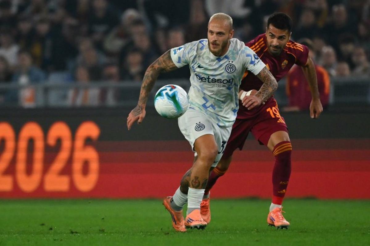 Inter Milan's Italian defender #32 Federico Dimarco fights for the ball with Roma's Turkish defender #19 Zeki Celik during the Italian Serie A football match between AS Roma and Inter Milan at the Olympic Stadium in Rome on October 18, 2025. Filippo MONTEFORTE / AFP