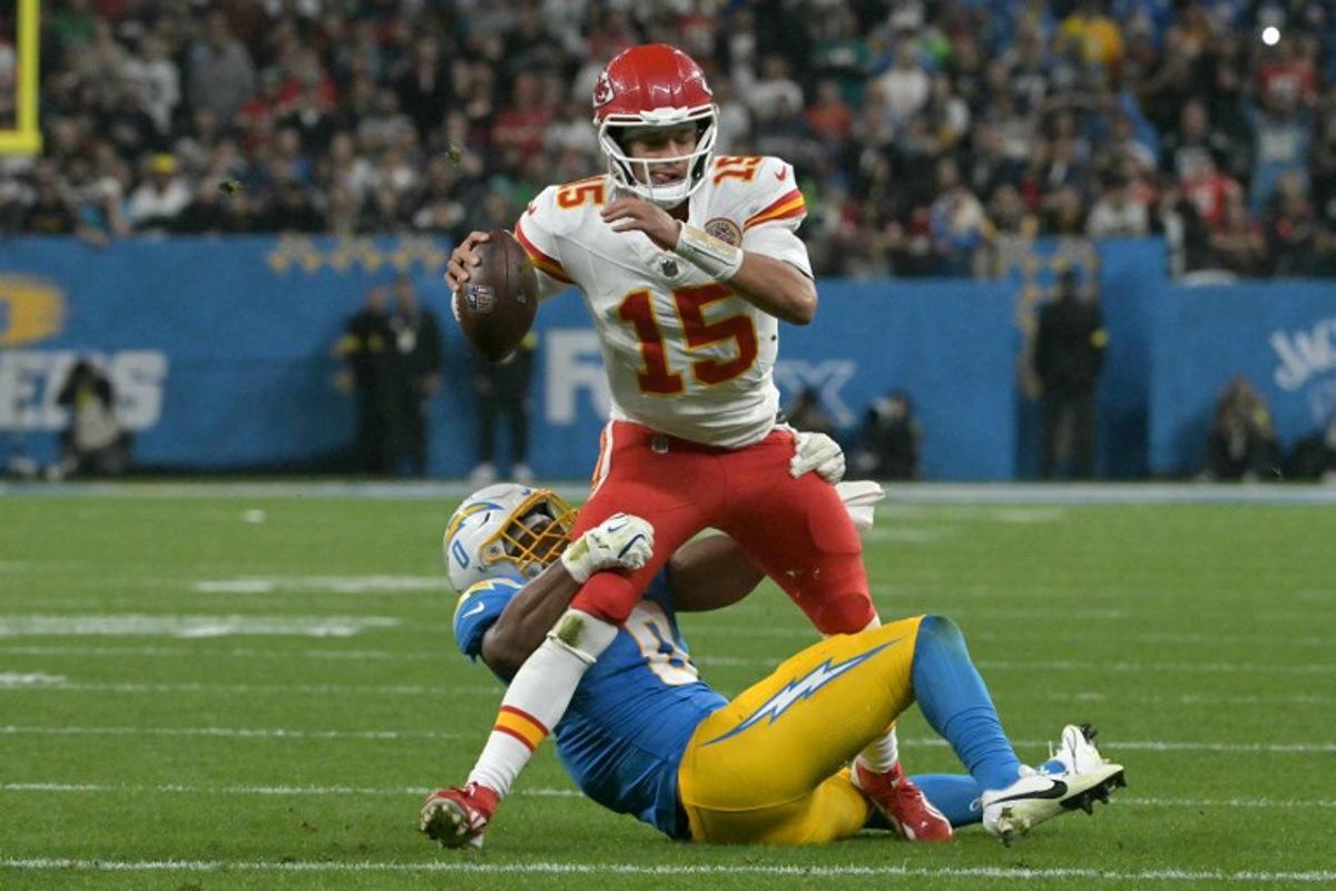 Kansas City Chiefs' quarterback #15 Patrick Mahomes is tackled by Los Angeles Chargers' linebacker #0 Daiyan Henley during the NFL game between the Kansas City Chiefs and Los Angeles Chargers at the Neo Quimica Arena Stadium in Sao Paulo, Brazil, on September 5, 2025. NELSON ALMEIDA / AFP