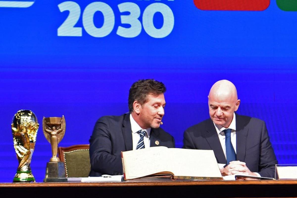 Conmebol's President Alejandro Dominguez (L) and FIFA Presdient Gianni Infantino (R) sign a book of minutes of the 2030 World Cup during Conmebol's 78th Ordinary Congress in Luque, Paraguay on April 11, 2024. NORBERTO DUARTE / AFP