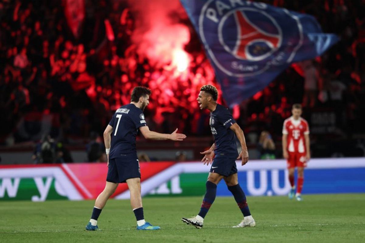 Paris Saint-Germain's Georgian forward #07 Khvicha Kvaratskhelia (L) celebrates with Paris Saint-Germain's French midfielder #14 Desire Doue after scoring his team first goal during the UEFA Champions League semi-final first leg football match between Paris Saint-Germain (PSG) and Bayern Munich at the Parc des Princes in Paris on April 28, 2026. Anne-Christine POUJOULAT / AFP