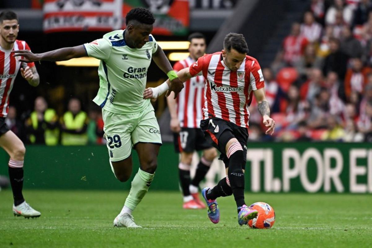 Athletic Bilbao's Spanish forward #07 Alex Berenguer (R) vies for the ball with Las Palmas' Portuguese midfielder #29 Dario Essugo during the Spanish league football match between Athletic Club Bilbao and UD Las Palmas at the San Mames stadium in Bilbao, on April 23, 2025. ANDER GILLENEA / AFP