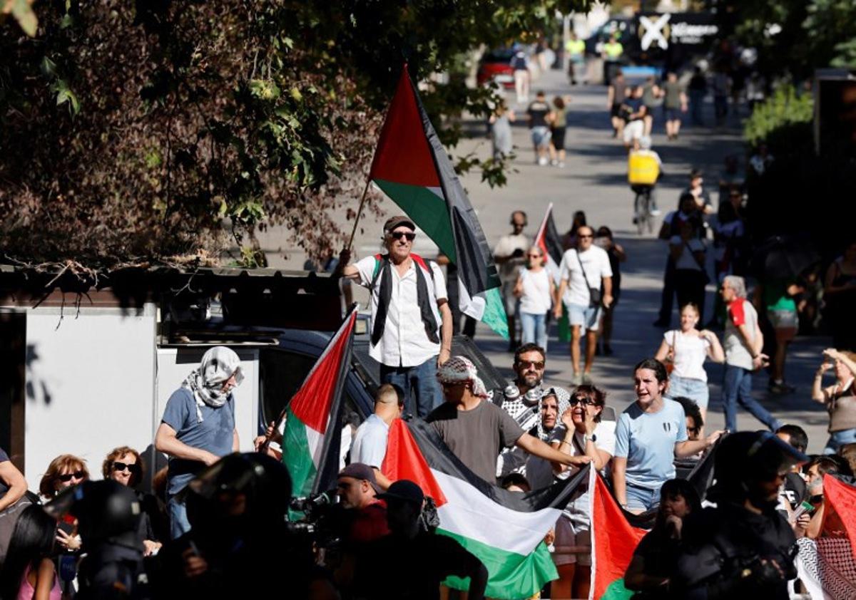 Pro-Palestinians protestors hold Palestinian flags during the 21st and last stage of the Vuelta a Espana 2025, a 101 km race between Alalpardo and Madrid, near Madrid's Atocha train station on September 14, 2025. The authorities have ramped up security for the Vuelta's final stage in Madrid, which was slightly shortened and will see 1,100 police officers deploy in the Spanish capital. Pierre-Philippe MARCOU / AFP