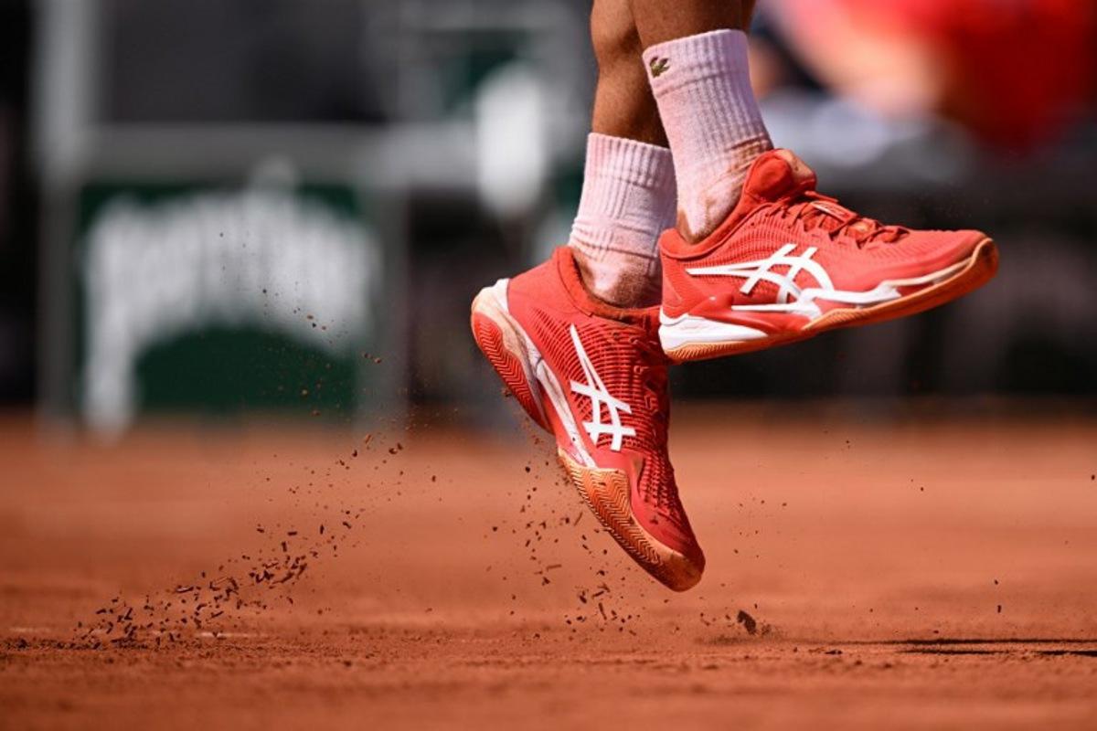 Clay fall as Serbia's Novak Djokovic serves to US Aleksandar Kovacevic during their men's singles match on day two of the Roland-Garros Open tennis tournament at the Court Philippe-Chatrier in Paris on May 29, 2023. Emmanuel DUNAND / AFP