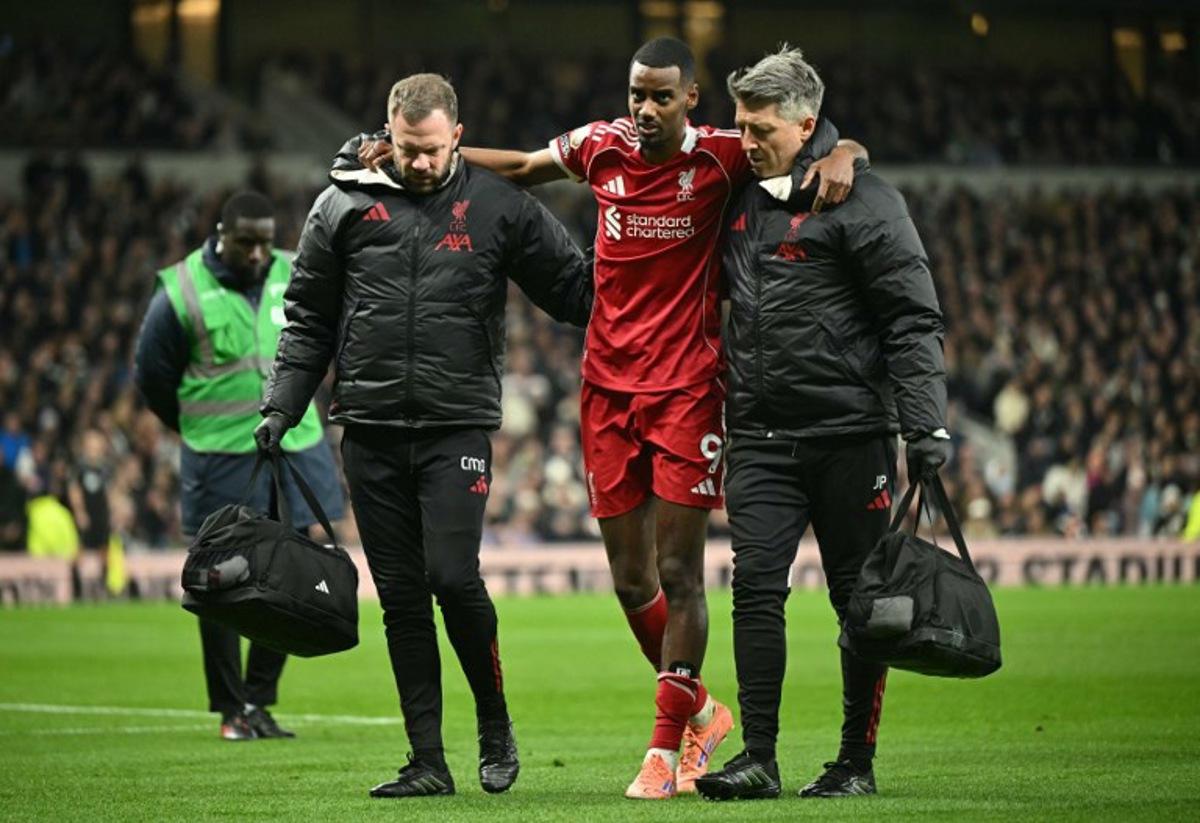 Liverpool's Swedish striker #09 Alexander Isak (C) is helped off the field by medical staff after picking up an injury during the English Premier League football match between Tottenham Hotspur and Liverpool at the Tottenham Hotspur Stadium in London, on December 20, 2025. JUSTIN TALLIS / AFP