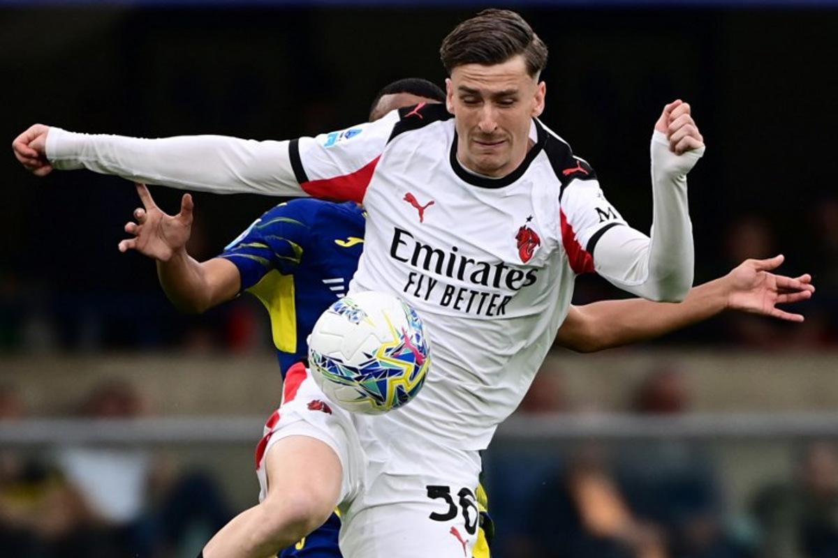 AC Milan's Belgian midfielder #56 Alexis Saelemaekers fights for the ball with Hellas Verona's defender #07 Rafik Belghali during the Italian Serie A football match between Hellas Verona and AC Milan at the Marcantonio Bentegodi stadium in Verona, on April 19, 2026. PIERO CRUCIATTI / AFP