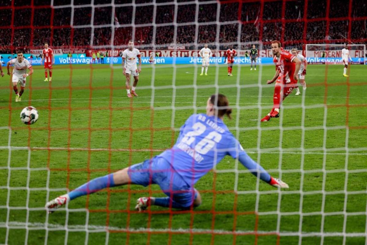 Bayern Munich's English forward #09 Harry Kane (R) scores the opening goal from the penalty spot past Leipzig's Belgian goalkeeper #26 Maarten Vandevoordt during the German Cup (DFB-Pokal) quarter-final football match between FC Bayern Munich and RB Leipzig in Munich, southern Germany on February 11, 2026. Alexandra BEIER / AFP