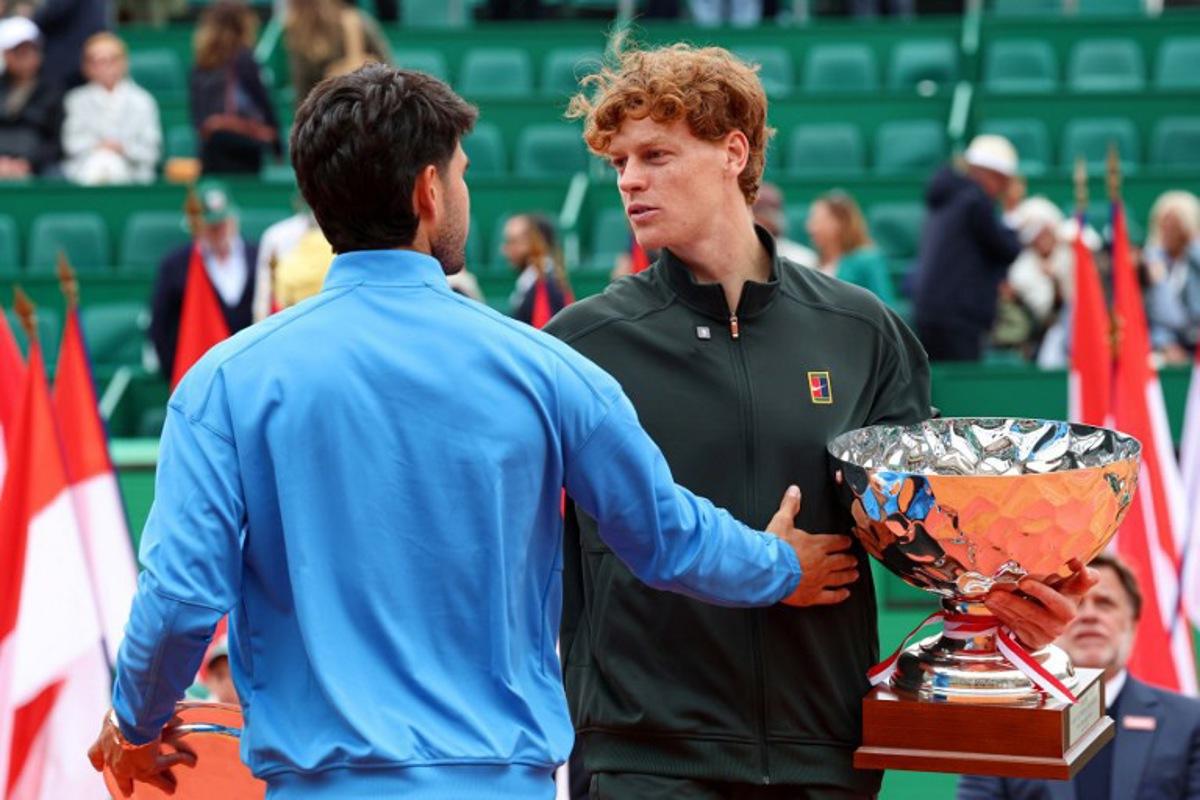 Italy's Jannik Sinner (R) embraces with Spain's Carlos Alcaraz after winning the Monte Carlo ATP Masters Series Tournament final tennis match on Court Rainier III at the Monte-Carlo Country Club in Roquebrune-Cap-Martin, south-eastern France on April 12, 2026. Valery HACHE / AFP