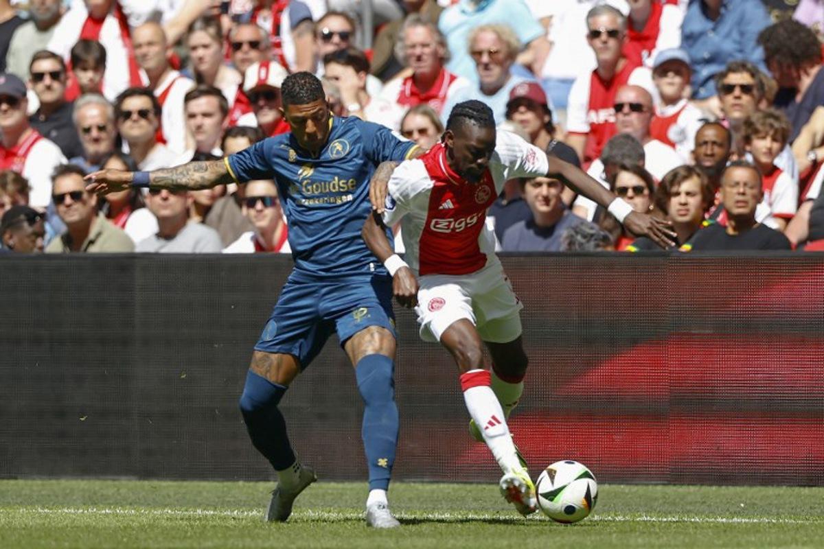 Sparta's Dutch defender #02 Patrick van Aanholt (L) and Ajax's Burkinabe forward #20 Bertrand Traore (R) fight for the ball during the Dutch Eredivisie match between AFC Ajax and Sparta Rotterdam at the Johan Cruijff Arena, in Amsterdam, on April 27, 2025. MAURICE VAN STEEN / ANP / AFP