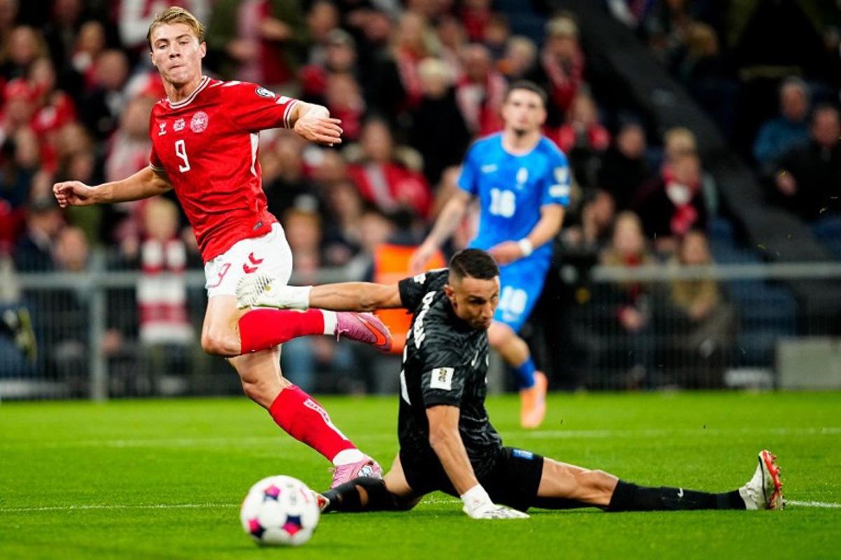 Denmark's forward #09 Rasmus Hojlund (L) scores the opening goal past Greece's goalkeeper #01 Odisseas Vlachodimos during the 2026 World Cup qualifiers Europe zone group G football match between Denmark and Greece on October 12, 2025 in Copenhagen. Mads Claus Rasmussen / Ritzau Scanpix / AFP