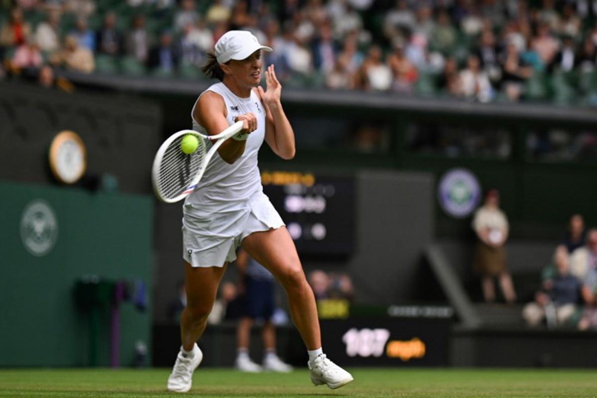 Poland's Iga Swiatek plays a forehand return to US player Danielle Collins during their women's singles third round tennis match on the sixth day of the 2025 Wimbledon Championships at The All England Lawn Tennis and Croquet Club in Wimbledon, southwest London, on July 5, 2025. Glyn KIRK / AFP