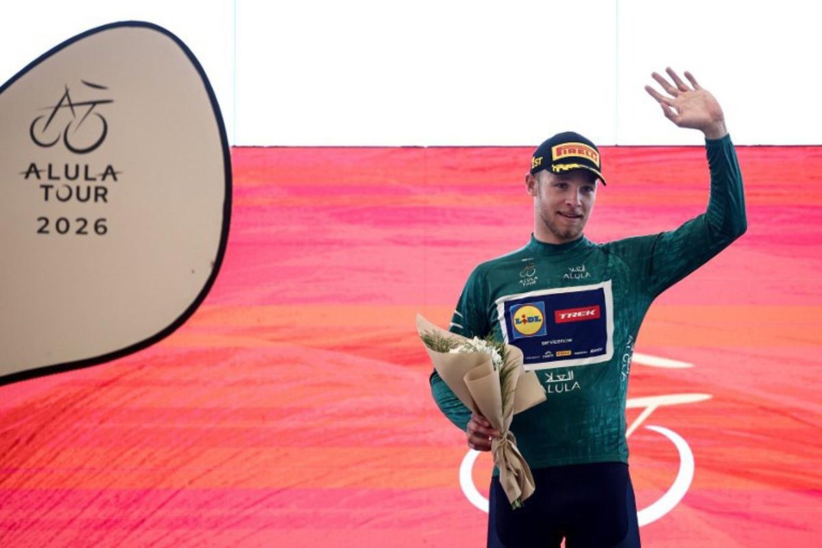 Lidl-Trek cycling team's Italian rider Jonathan Milan celebrates on the podium after winning the first stage of the AlUla Tour cycling race, a 158 km race started and finished in the Saudi desert city of AlUla, on January 27, 2026. Anne-Christine POUJOULAT / AFP
