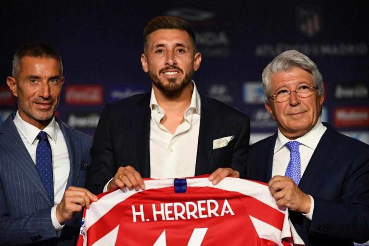 Atletico Madrid's new Mexican midfielder Hector Herrera holds his new jersey next to the Spanish football club's president Enrique Cerezo (R) and sports director Andrea Berta (L) during his official presentation at the Wanda Metropolitan stadium in Madrid on July 5, 2019. GABRIEL BOUYS / AFP