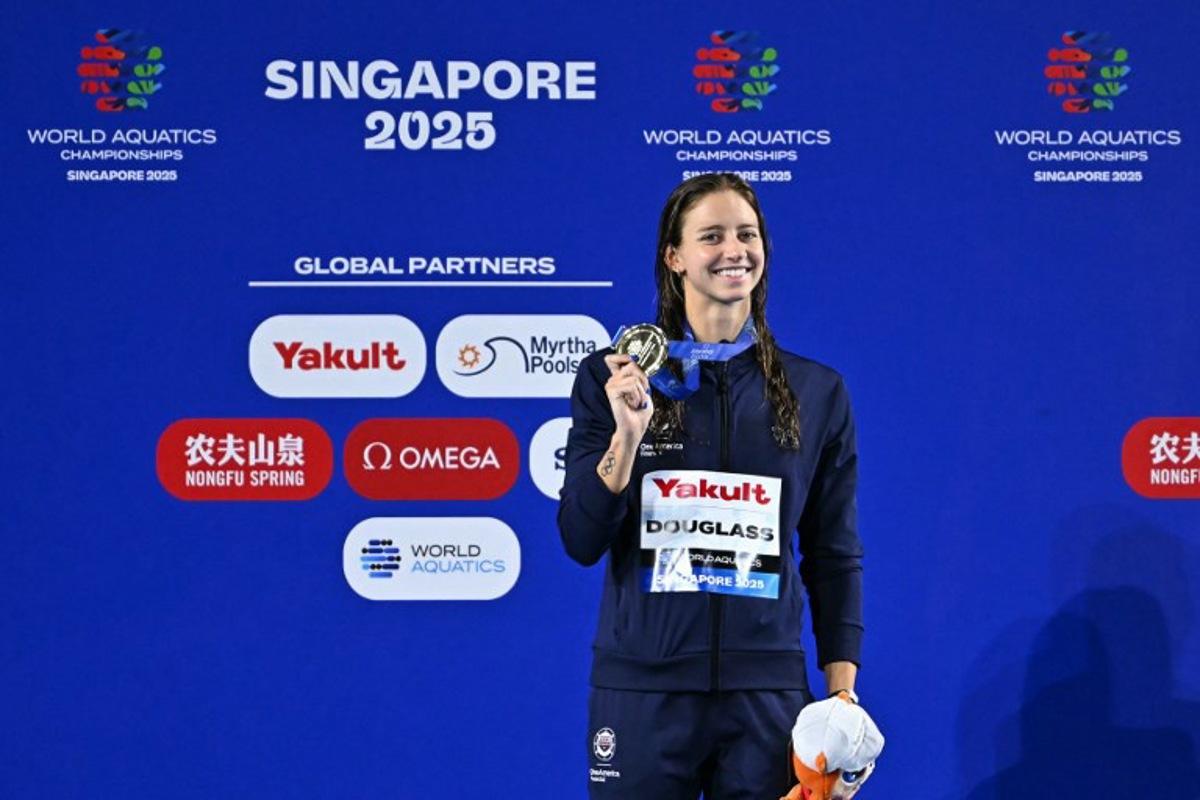 Gold medallist US' swimmer Kate Douglass celebrates on the podium of the women's 200m breaststroke swimming event during the 2025 World Aquatics Championships in Singapore on August 1, 2025. MANAN VATSYAYANA / AFP