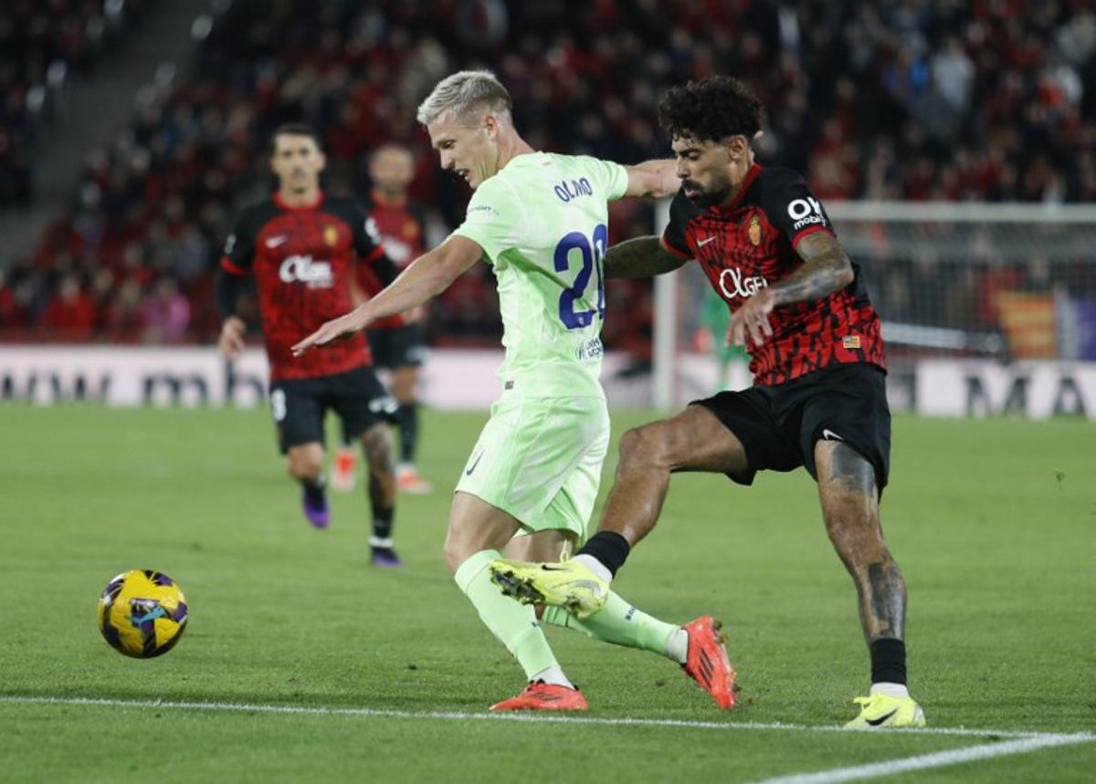 Barcelona's Spanish midfielder #20 Dani Olmo (L) vies with Real Mallorca's Portuguese midfielder #12 Samu Costa during the Spanish league football match between RCD Mallorca and FC Barcelona at the Mallorca Son Moix stadium in Palma de Mallorca on December 3, 2024. JAIME REINA / AFP