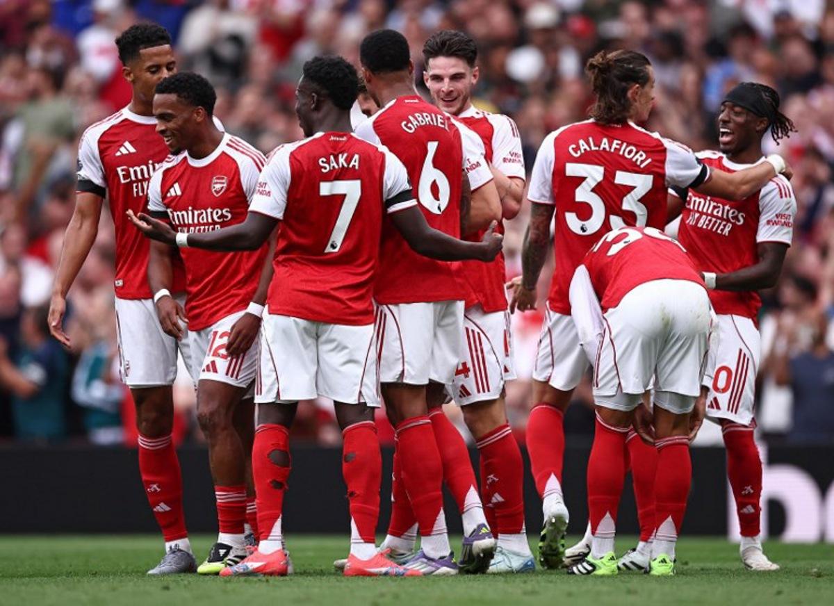 Arsenal's Dutch defender #12 Jurrien Timber (2L) is mobbed by teammates after scoring the opening goal during the English Premier League football match between Arsenal and Leeds United at the Emirates Stadium in London on August 23, 2025. HENRY NICHOLLS / AFP
