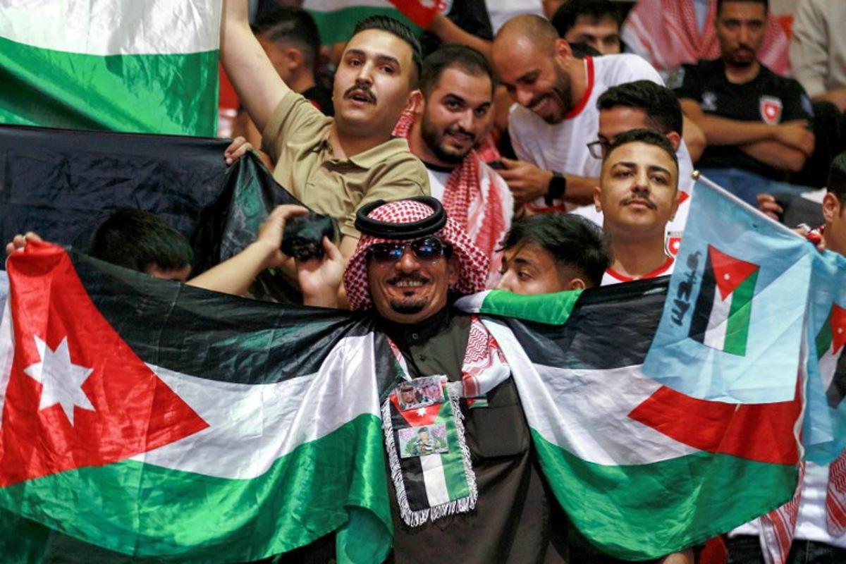 Jordan's fans cheer as they watch the 2026 FIFA World Cup Asian Qualifier football match between Jordan and Oman on big screens at the Prince Hamza hall in the Sports City in Amman on June 5, 2025. Khalil MAZRAAWI / AFP