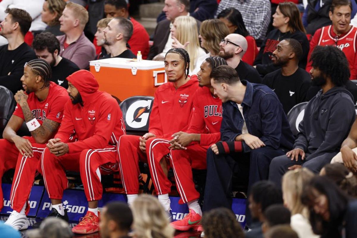 Chicago Bulls' French forward #24 Noa Essengue (C), smiles as he sits on the bench during the first half of an NBA game against the Detroit Pistons at the United Center in Chicago, Illinois, on October 22 2025. KAMIL KRZACZYNSKI / AFP