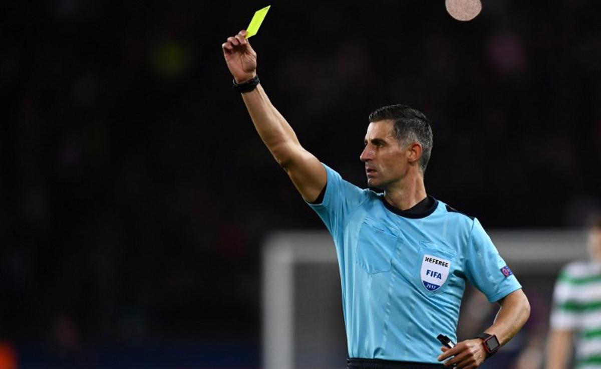 Greece's referee Tasos Sidiropoulos issues a yellow card during the UEFA Champions League Group B football match between Paris Saint-Germain (PSG) and Glasgow Celtic at Parc des Princes Stadium in Paris on November 22, 2017. FRANCK FIFE / AFP