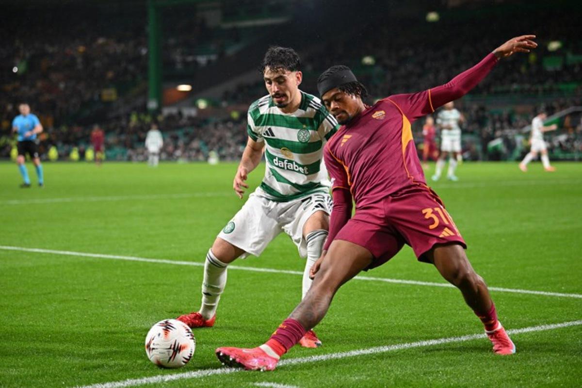 Celtic's Tunisian striker #23 Sebastian Tounekti (L) battles with Roma's Jamaican forward #31 Leon Bailey (R) during the UEFA Europa League league stage football match between Celtic and Roma at Celtic Park in Glasgow on December 11, 2025. ANDY BUCHANAN / AFP