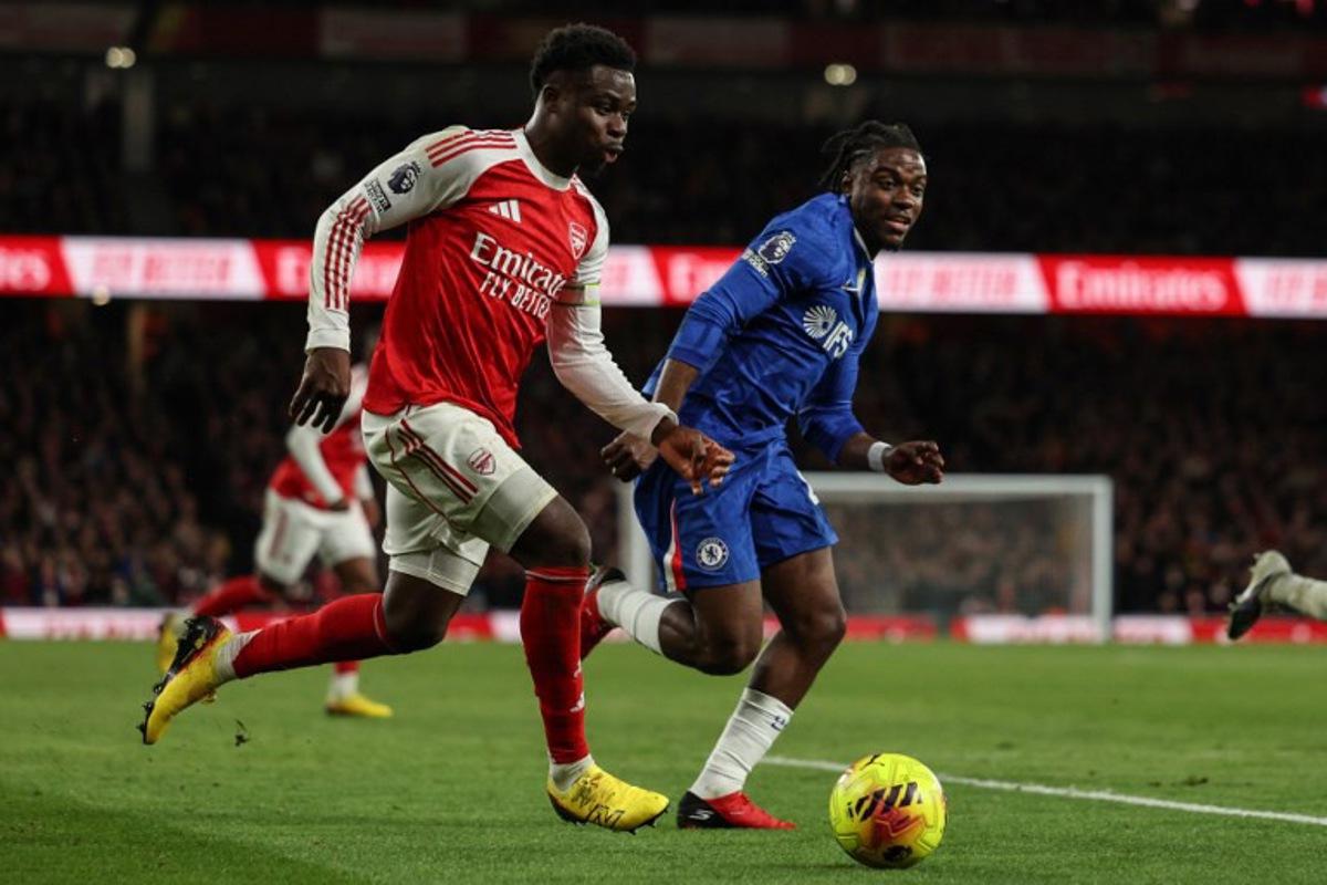 Chelsea's Belgian midfielder #45 Romeo Lavia (R) chases after Arsenal's English midfielder #07 Bukayo Saka (L) during the English Premier League football match between Arsenal and Chelsea at the Emirates Stadium in London on March 1, 2026. Adrian Dennis / AFP