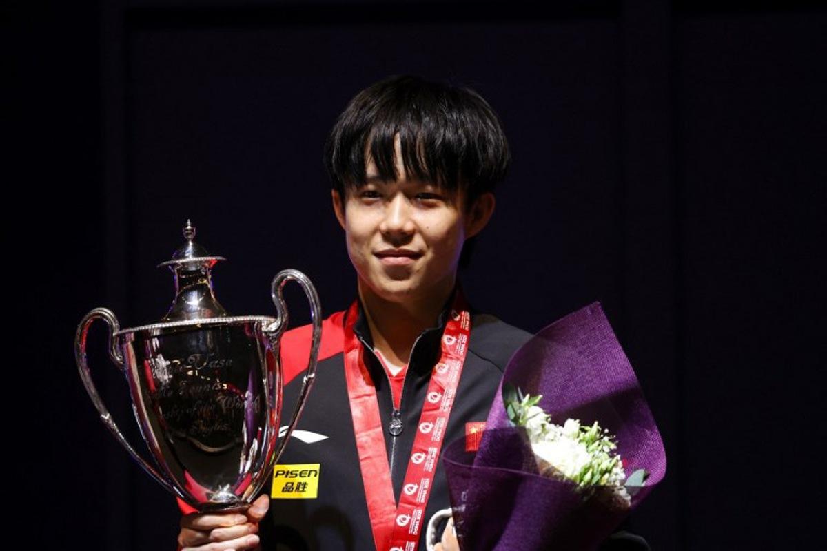 China's Wang Chuqin poses with his first-place trophy on the podium after the men's singles of the ITTF World Table Tennis Championship finals in Doha on May 25, 2025. Karim JAAFAR / AFP