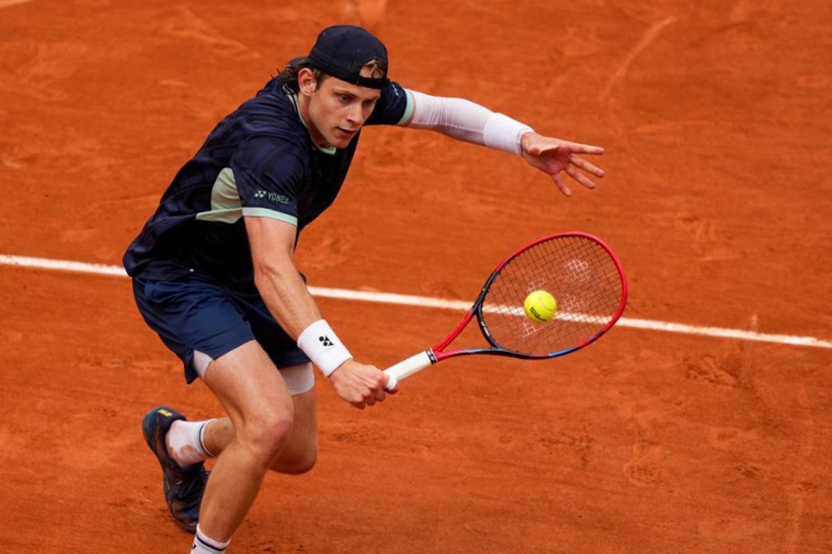 Belgium's Zizou Bergs plays a backhand return to France's Giovanni Mpetshi Perricard during their men's singles match on day 1 of the French Open tennis tournament on Court Suzanne-Lenglen at the Roland-Garros Complex in Paris on May 25, 2025. Dimitar DILKOFF / AFP