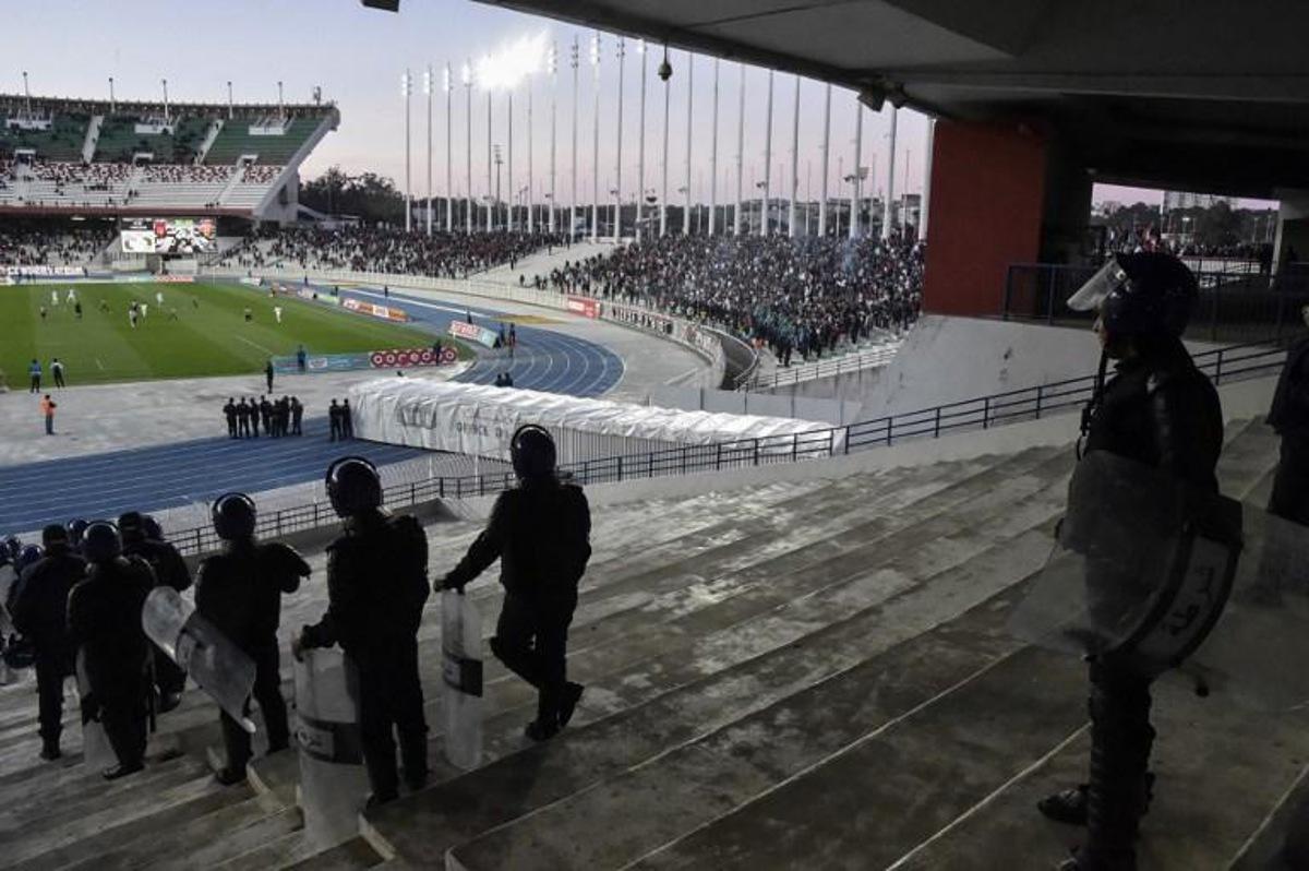 Algerian security forces stand guard during the game between national rival football clubs at the 5 July stadium in the outskirts of central Algiers on March 14, 2019. The Algiers derby on March 14 between the capital's rival football clubs, USM Alger and MC Alger, had a low attendance following a call for fans to stay away from the rescheduled match over fears of potential trouble. RYAD KRAMDI / AFP